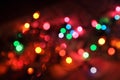 Glowing and festive colored light circles created from in camera and lens bokeh. Christmas fairy lights defocused giving a blurred