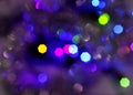 Glowing and festive colored light circles created from in camera and lens bokeh. Christmas fairy lights defocused giving a blurred