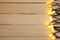 Glowing festive lights on wooden background, top view. Space for text