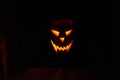 Glowing fiery Jack-o`-lantern face from a pumpkin with candle on a halloween