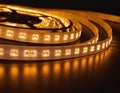Glowing Flexible LED Strip Lights on Spools Emitting Warm Yellow Light Royalty Free Stock Photo
