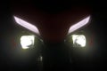 glowing front headlights of a motorcycle in the dark close up Royalty Free Stock Photo