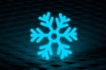 Glowing frozen snowflake on dark wall. Neon effect. Large snowfalls in winter