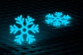 Glowing frozen snowflakes on dark wall. Neon effect. Large snowfalls in winter