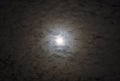 Glowing full moon surrounded by layers of moody soft clouds lit Royalty Free Stock Photo