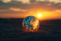 A glowing globe of earth in a desolate sunset landscape symbolizes climate change concerns Royalty Free Stock Photo