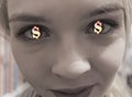 Glowing gold dollar signs in eyes of a young girl. the concept of chasing money and greed