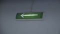 Glowing green arrow on wall. Clip. Arrow on green background lights up to indicate exit. Arrow of evacuation exit glows Royalty Free Stock Photo