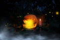 Glowing Halloween jack-o-lantern pumpkin in a misty forest. Helloween pumpkin with evil face in a magic foggy place Royalty Free Stock Photo