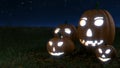 Glowing halloween pumpkins on grass field with dark sky Royalty Free Stock Photo