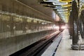 Glowing headlights of train leaving tunnel to underground metro station. Royalty Free Stock Photo