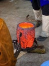 Glowing hot crucible full of melted bronze.