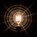 A glowing incandescent light bulb is centered against a dark Royalty Free Stock Photo