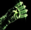 Glowing kirlian aura photography with green corona of a male human hand