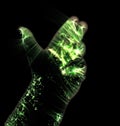 Glowing kirlian aura photography with green corona of a male human hand