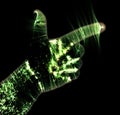 Glowing kirlian aura photography with green corona of a male human hand