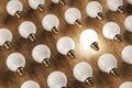 Glowing lamp and many lamps on wooden background