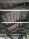 Glowing lamps hanging under ceiling and ventilation ducts