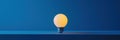 Glowing light bulb on blue background, modern design, minimalistic style, soft illumination, creative lighting concept Royalty Free Stock Photo