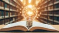 glowing light bulb effect emerges from open book in library symbolizing knowledge and inspiration warm light creates inviting Royalty Free Stock Photo