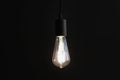 Glowing light bulb hanging on dark background Royalty Free Stock Photo