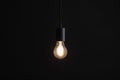 Glowing light bulb hanging on dark background Royalty Free Stock Photo