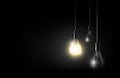 Glowing light bulb is hanging between a lot of turned off light bulbs on dark black background, copyspace, transparent vector Royalty Free Stock Photo