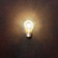 Glowing light bulb. Realistic image of included tungsten light bulb on gray background, top view. Creative idea concept