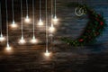 Glowing light bulbs hang on a long cord against the background of a wooden wall Royalty Free Stock Photo