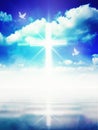 Glowing light Christian cross on blue sky, white doves, water mirror reflection Royalty Free Stock Photo