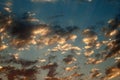 GLOWING LIGHT ON SCATTERED CLOUDS IN A BLUE SKY AT SUNSET Royalty Free Stock Photo