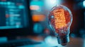 glowing lightbulb made of holographic code matrix, symbolizing innovation and technology. background features blurred computer Royalty Free Stock Photo