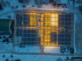 Glowing modern glass greenhouse in winter night, top view