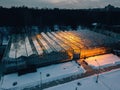 Glowing modern glass greenhouse in winter night, top view