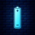 Glowing neon Battery icon isolated on brick wall background. Vector