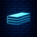 Glowing neon Books icon isolated on brick wall background. Vector