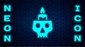 Glowing neon Burning candle on a skull icon isolated on brick wall background. Day of dead. Vector