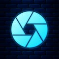 Glowing neon Camera shutter icon isolated on brick wall background. Vector