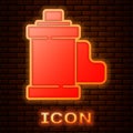 Glowing neon Camera vintage film roll cartridge icon isolated on brick wall background. 35mm film canister. Filmstrip