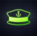 Glowing neon Captain hat icon isolated on brick wall background. Vector