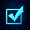 Glowing neon Check mark in a box icon isolated on brick wall background. Tick symbol. Check list button sign. Vector