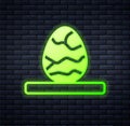 Glowing neon Chinese tea egg icon isolated on brick wall background. Vector