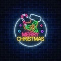 Glowing neon christmas sign with christmas sock, candy cane and holly in circle frame . Christmas symbol in neon style.