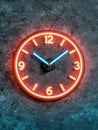 Glowing neon clock on dark textured background Royalty Free Stock Photo