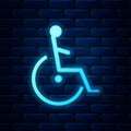 Glowing neon Disabled handicap icon isolated on brick wall background. Wheelchair handicap sign Royalty Free Stock Photo