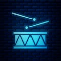 Glowing neon Drum with drum sticks icon isolated on brick wall background. Music sign. Musical instrument symbol. Vector