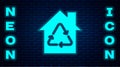 Glowing neon Eco House with recycling symbol icon isolated on brick wall background. Ecology home with recycle arrows