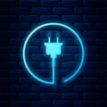 Glowing neon Electric plug icon isolated on brick wall background. Concept of connection and disconnection of the