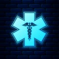 Glowing neon Emergency star - medical symbol Caduceus snake with stick icon isolated on brick wall background. Star of