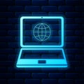 Glowing neon Globe on screen of laptop icon isolated on brick wall background. Notebook computer with globe sign. Vector